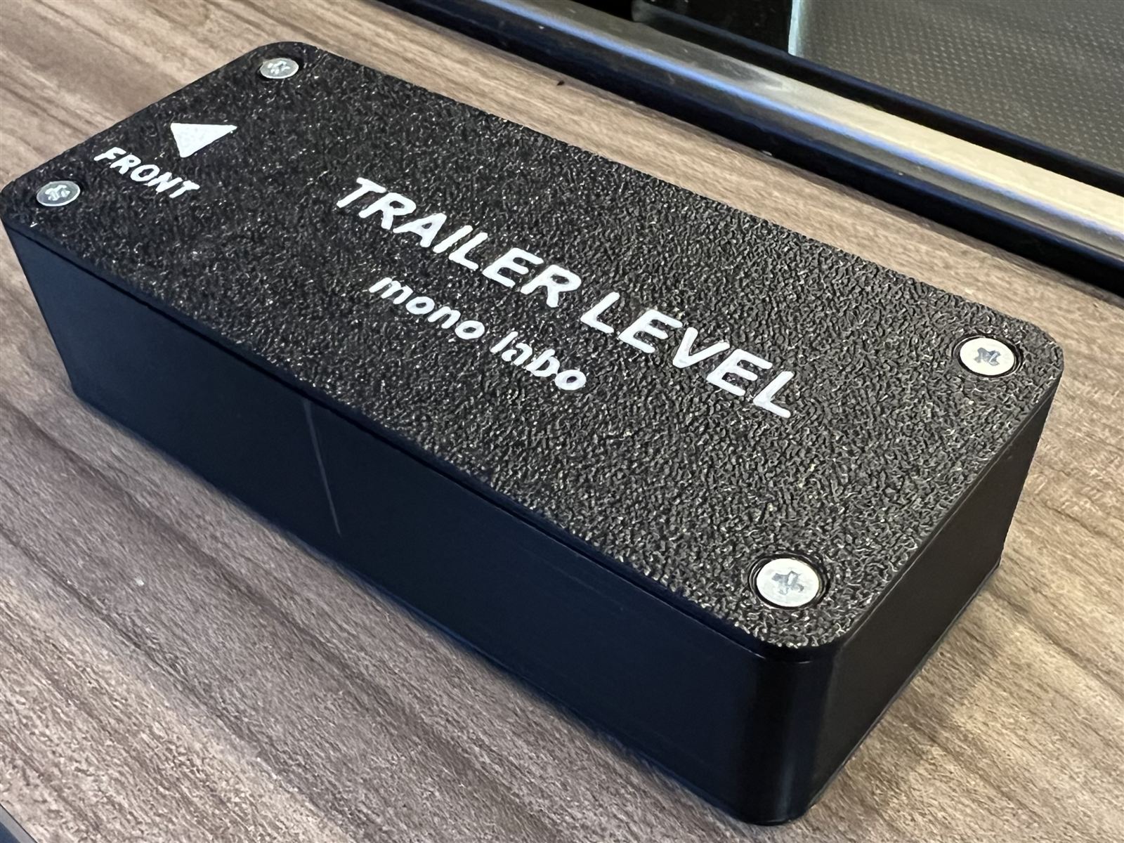 TrailerLevel本体。シボ加工の3Dプリント筐体にTRAILER LEVELのロゴ